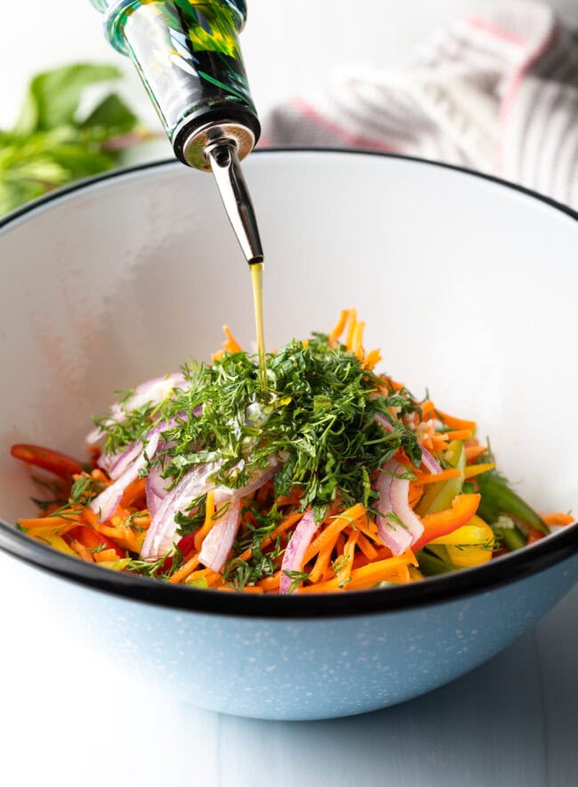 Pepper salad adding olive oil.