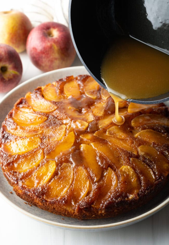 Pouring whiskey sauce onto the apple cake.