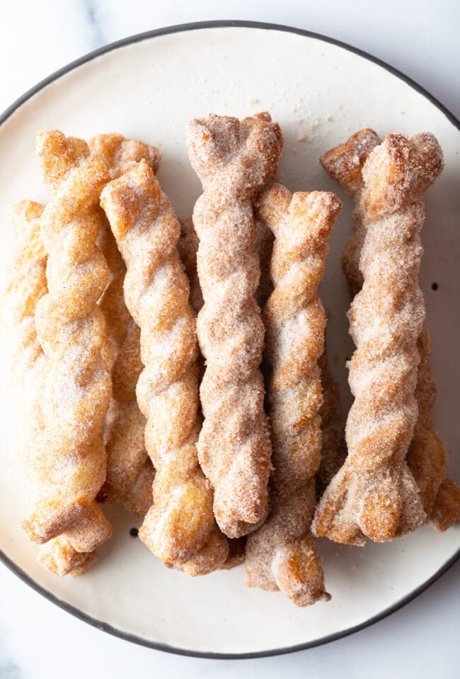 Top view crispy cinnamon twists on a plate.