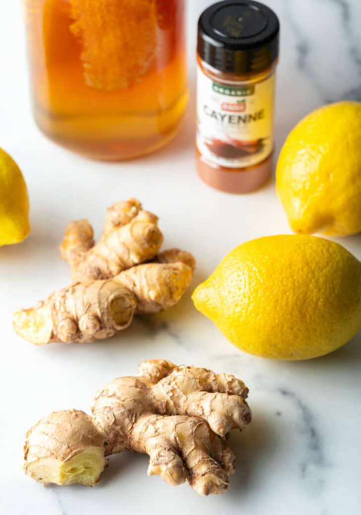 Ingredients you need: Two whole yellow lemons, two ginger roots, jar of honey, bottle of turmeric spice.