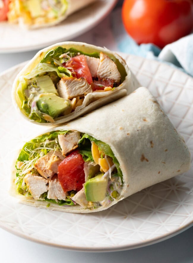 Top down view loaded chicken wrap, two pieces of the wrap are lying criss cross on each other.