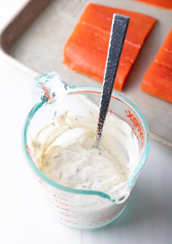 Glass mixing jar with creamy dill mayo dressing.