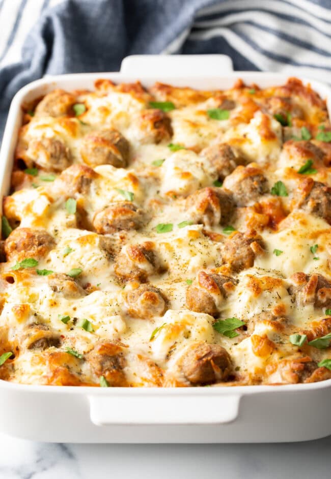 Baked dump and bake meatball casserole in a white dish, bubbly cheese on top.