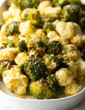 White oval platter loaded with roasted broccoli and cauliflower florets.