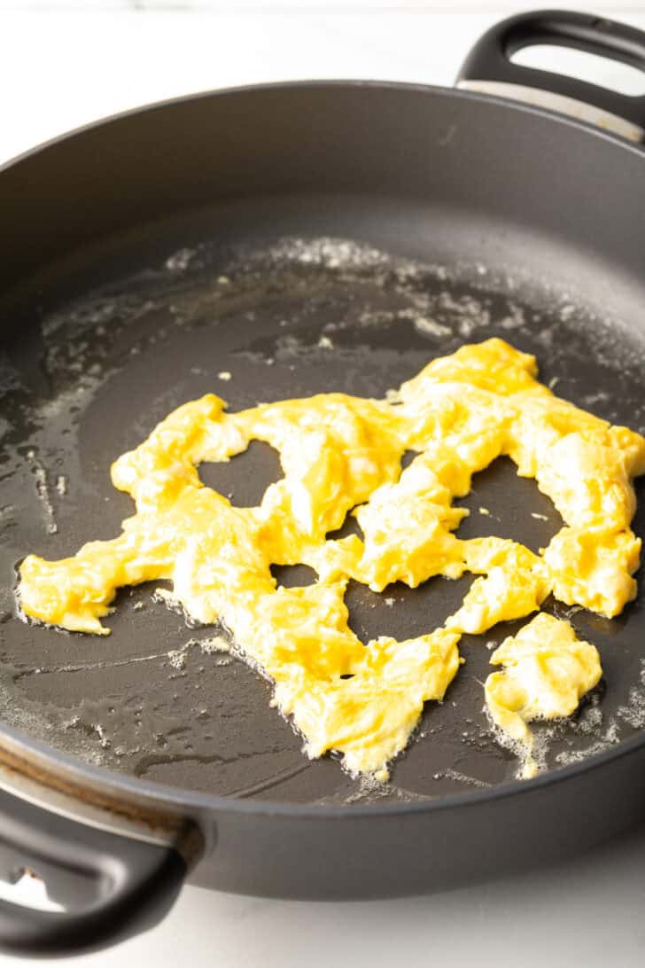 Scrambling eggs in a skillet.