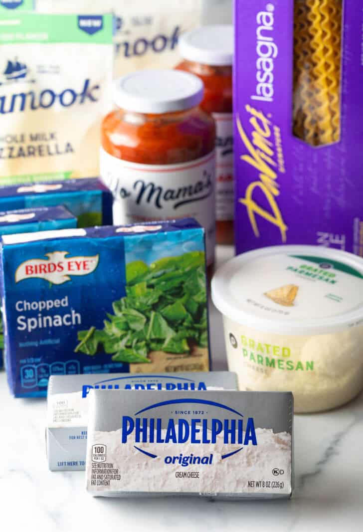 Recipe ingredients: Box of frozen chopped spinach, two boxes of cream cheese, container of parmesan cheese, jar of marinara sauce, bag of shredded mozzarella, and box of lasagna noodles