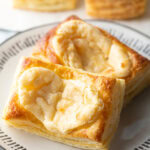 Two large Starbucks style cream cheese danishes on a white plate.