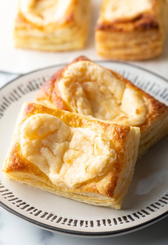 Two large Starbucks style cream cheese danishes on a white plate.