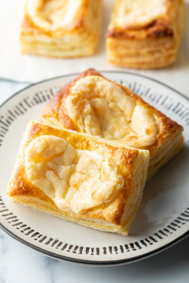 Two large Starbucks style cream cheese danishes on a white plate.