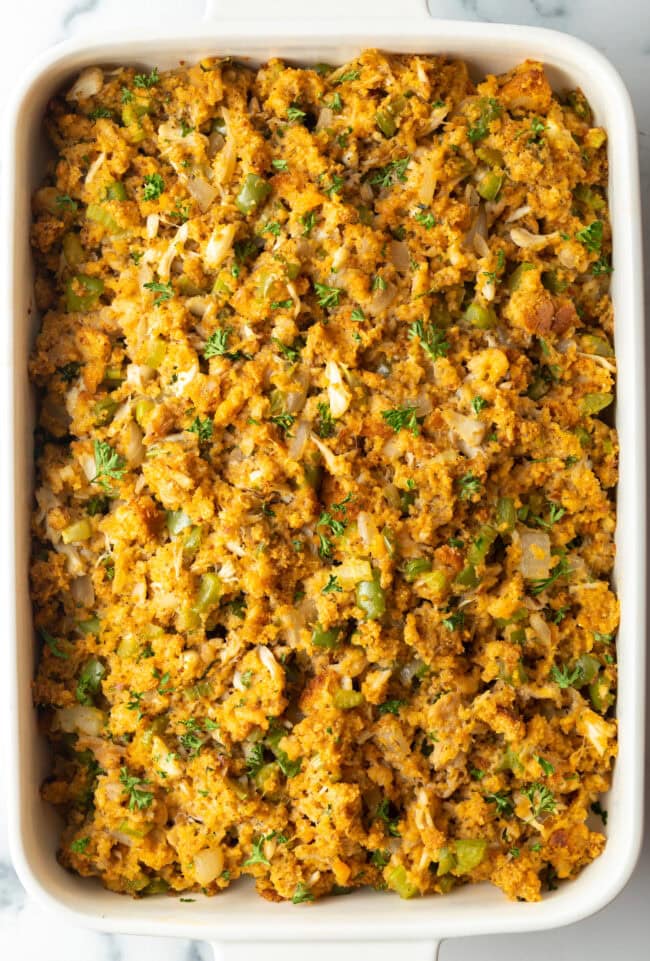 Top down view of baked seafood dressing in a white rectangle baking dish.