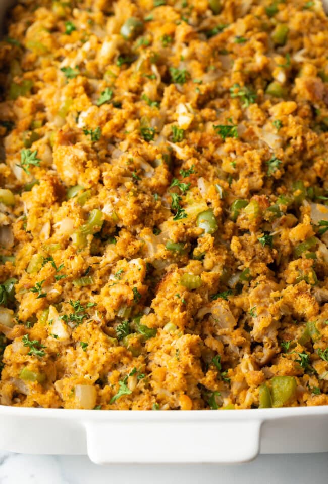 Top down view of baked seafood dressing in a white rectangle baking dish.