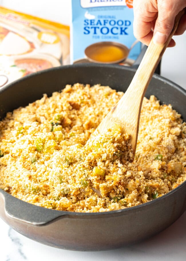 Cooking breadcrumbs in a heavy skillet with wooden spatula.