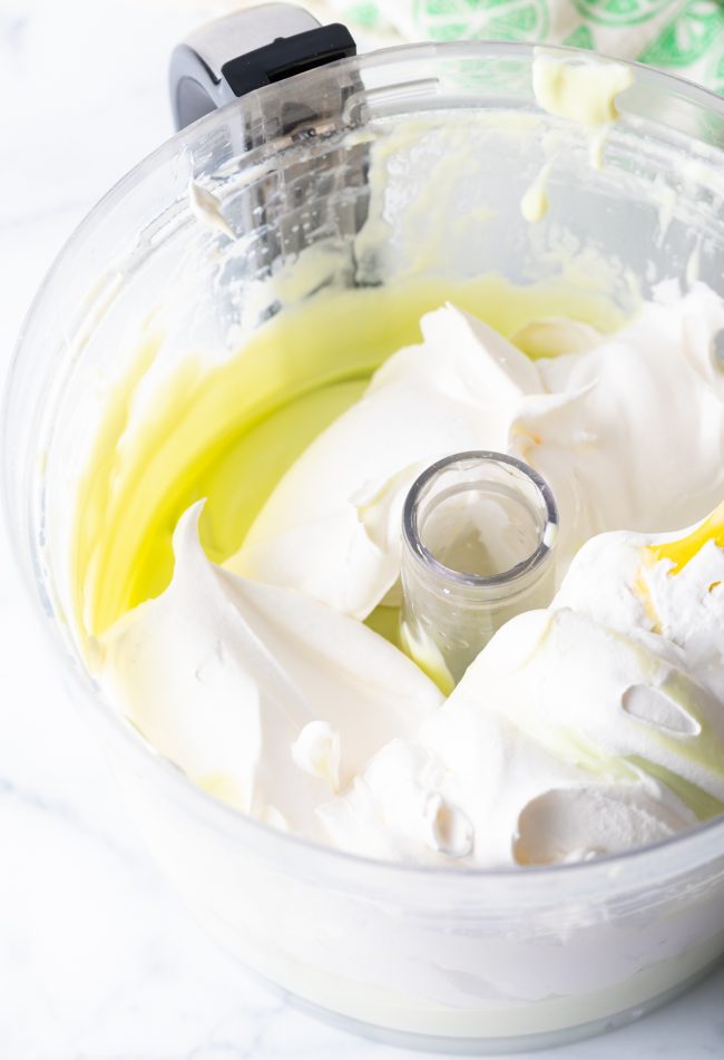 Adding cool whip to the key lime filling in the food processor.