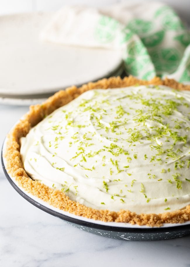 Key lime ice box pie garnished with zest in a pie pan. 