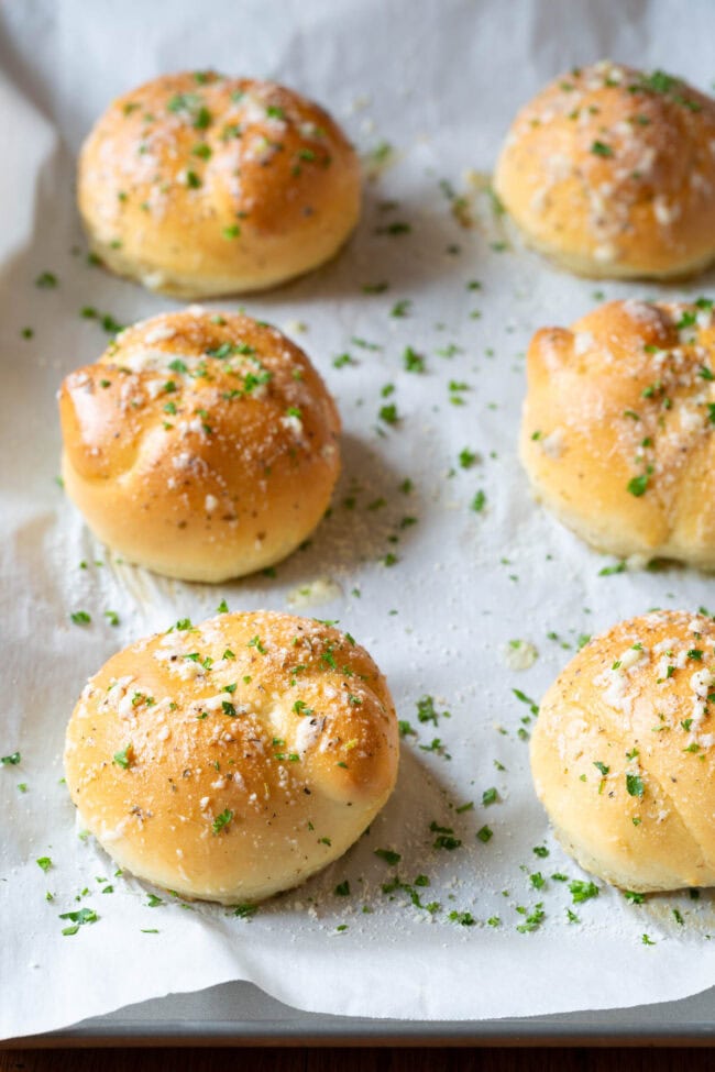 Garlic Knots lined up on a baking sheet.