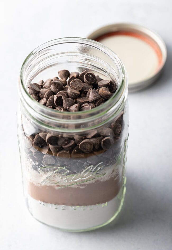 Topping the jar of homemade brownie mix with chocolate chips.