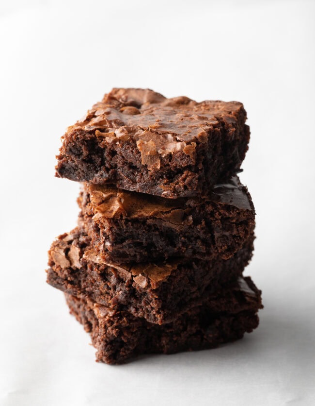 Stack of 4 brownies on a white background.