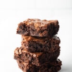 Stack of 4 brownies on a white background.