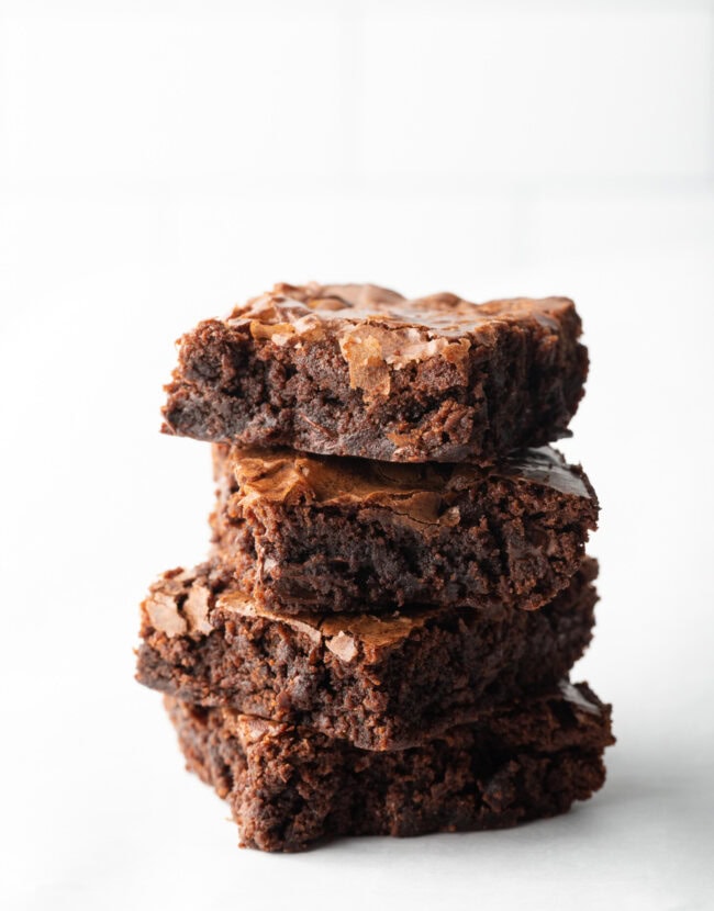 Stack of 4 brownies on a white background from homemade ghirardelli brownie mix.