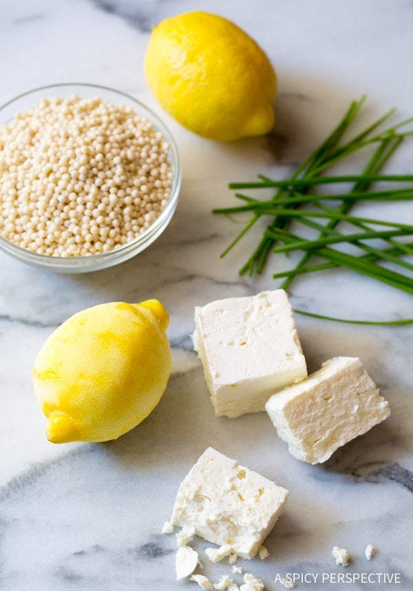 Ingredients needed for lemon chicken soup on a marble counter. 