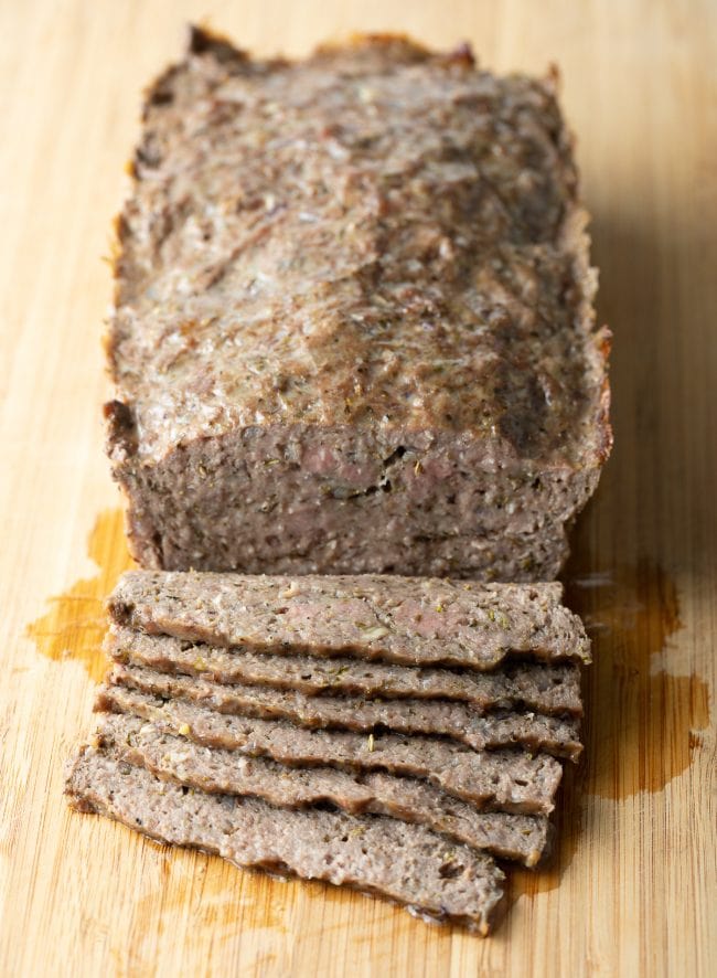 Sliced lamb meatloaf on a cutting board. 