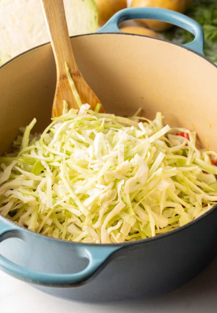 Large blue cooking pot with shredded cabbage.