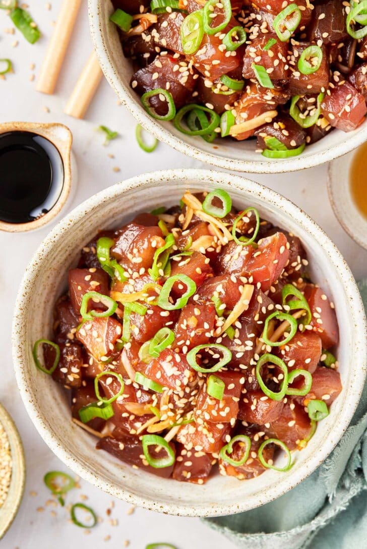 Overhead shot of ahi poke in a bowl with sesame seeds and green onions on top. 