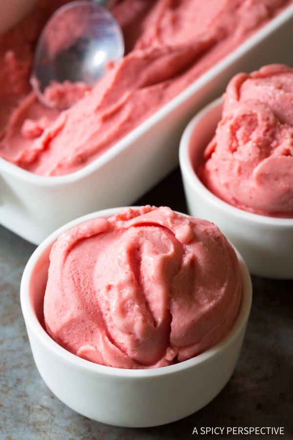 A white bowl of a serving of strawberry sherbet.