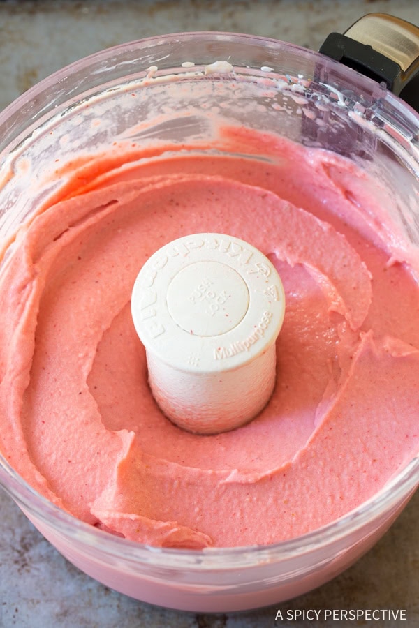 Strawberry sherbet blended in a food processor bowl.