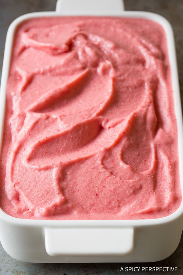 Strawberry pineapple sherbet in a white serving dish.