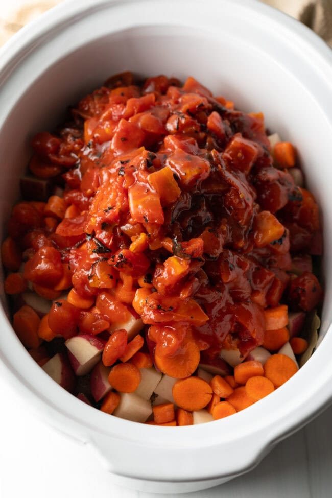 Diced potatoes, carrots, and canned tomatoes added to the mix.