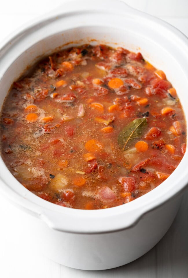 Simmering stew in a white slow cooker.