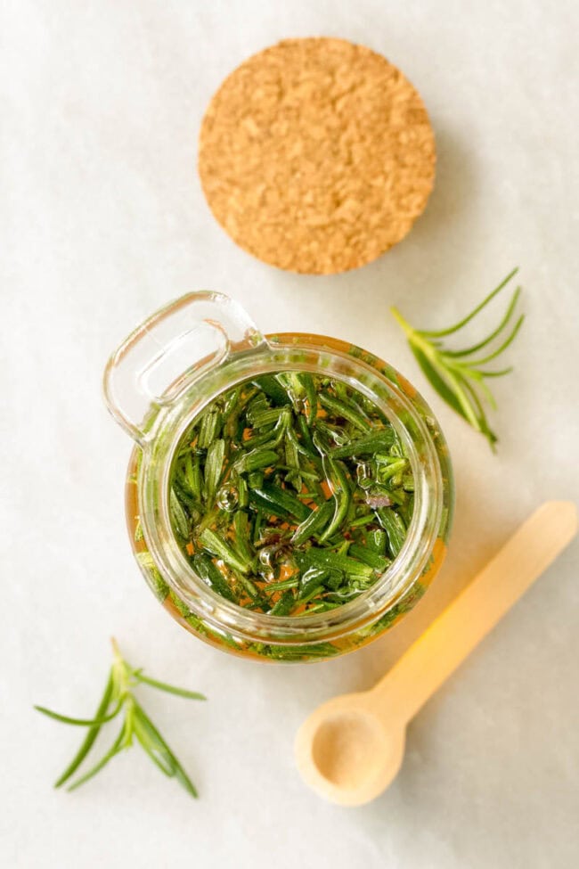 Infused Honey Recipe - Overhead shot of herbs soaking in the honey in a small jar. 