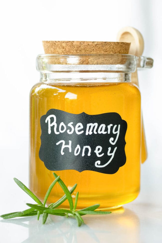 Infused Honey - Small glass container filled with honey and labeled "rosemary honey"