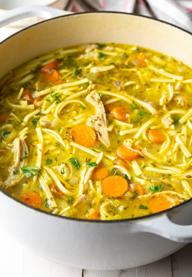 Homemade chicken soup recipe on the stove in a pot.