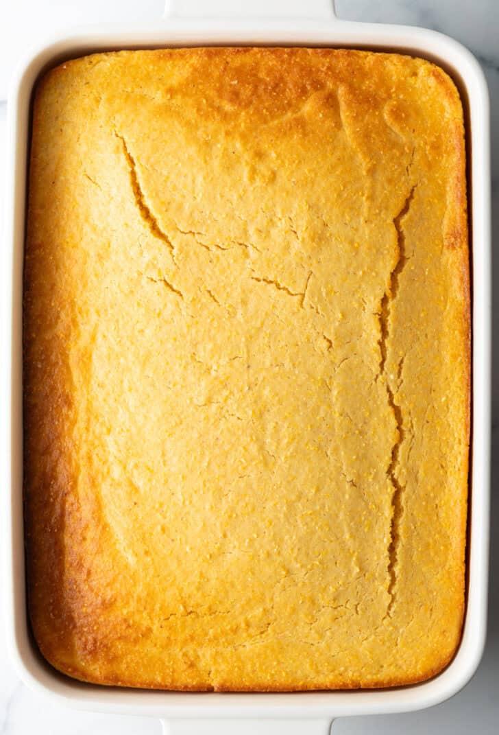 White rectangle baking dish with fluffy yellow cornbread.