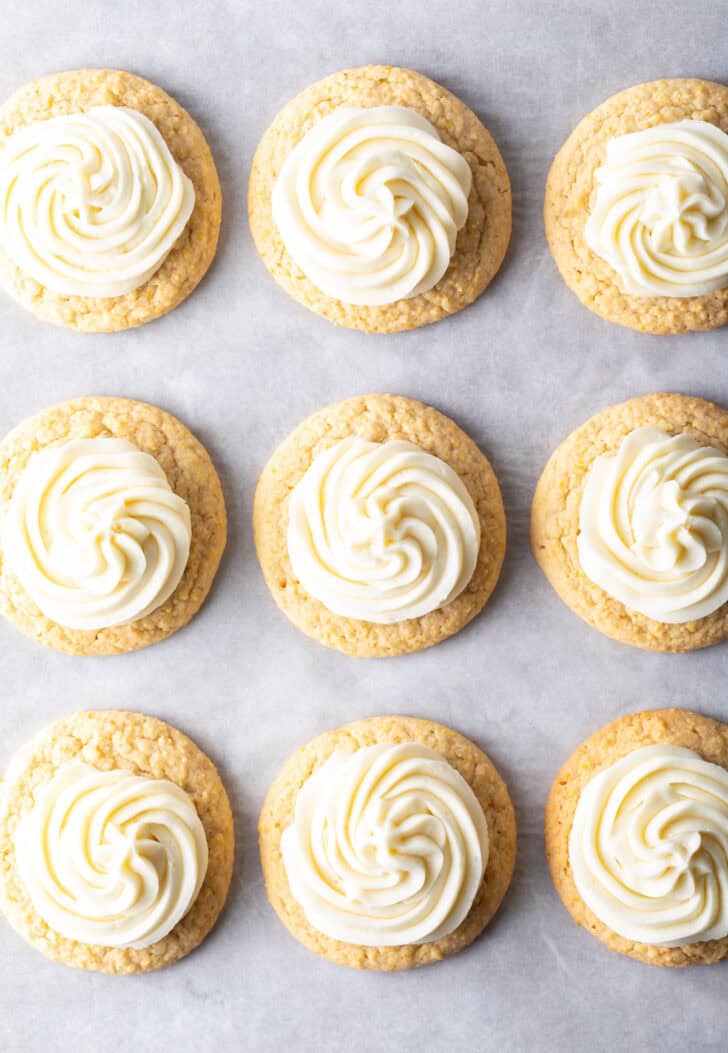 Top down view 9 frosted honey butter cookies on a baking sheet.