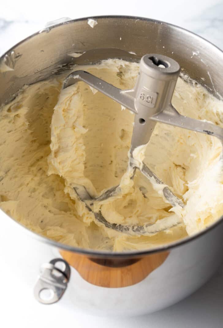 Honey buttercream frosting in a metal standing mixer bowl.