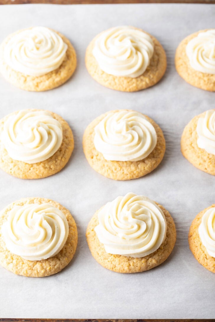 9 frosted honey butter cookies on a baking sheet.