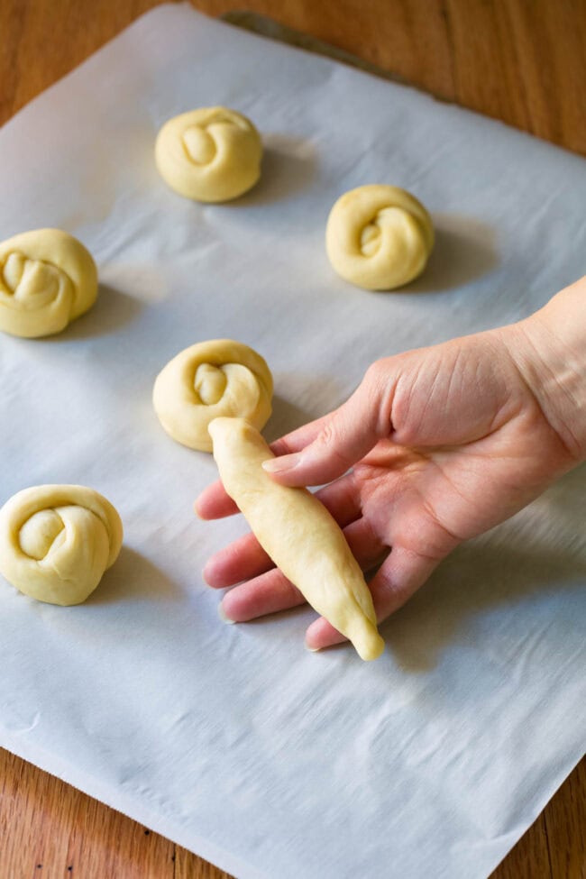 Hand holding a log of yeast dough. 