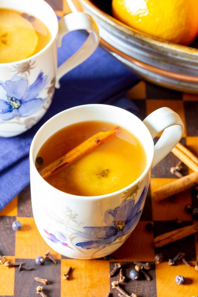 Mug of wassail cider with a cinnamon stick in the mug. 