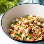 Salad with ancient grains, chopped herbs, peppers, and cheese tossed with lemon vinaigrette.