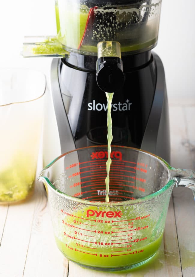 Celery being juiced in a juicer. 