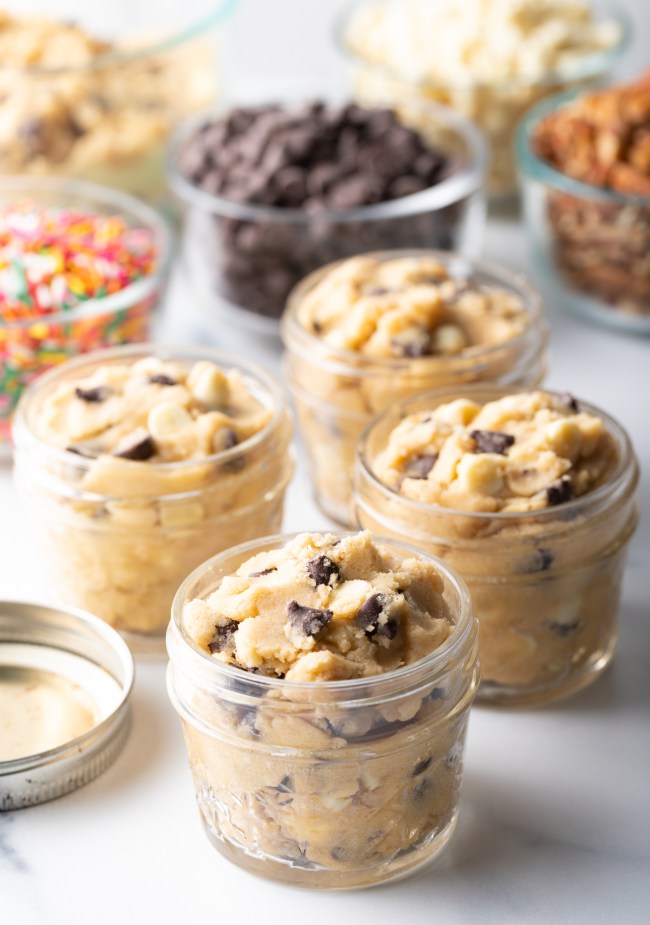 Four small glass containers with unbaked cookie dough.