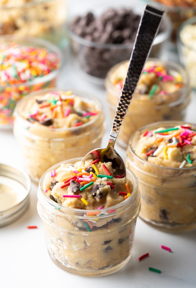 Metal spoon with raw cookie dough and sprinkles,