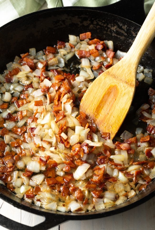 Bacon and onion sautéing in a pan. 