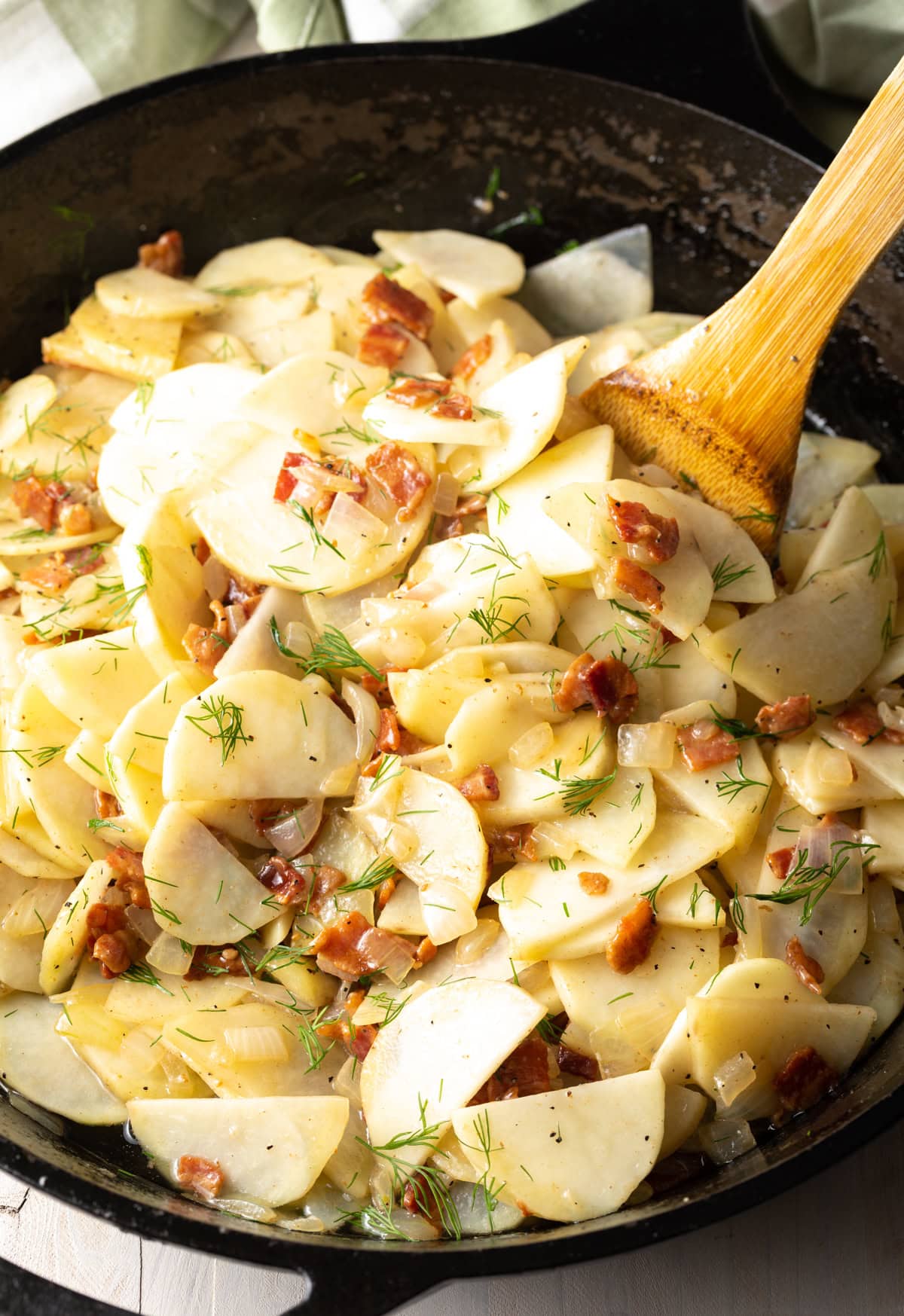 Potatoes, bacon, onions and dill cooking in a pan. 