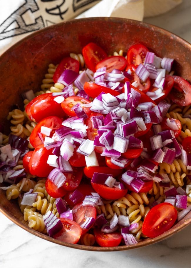 Pasta salad ingredients in a bowl before mixing them. 