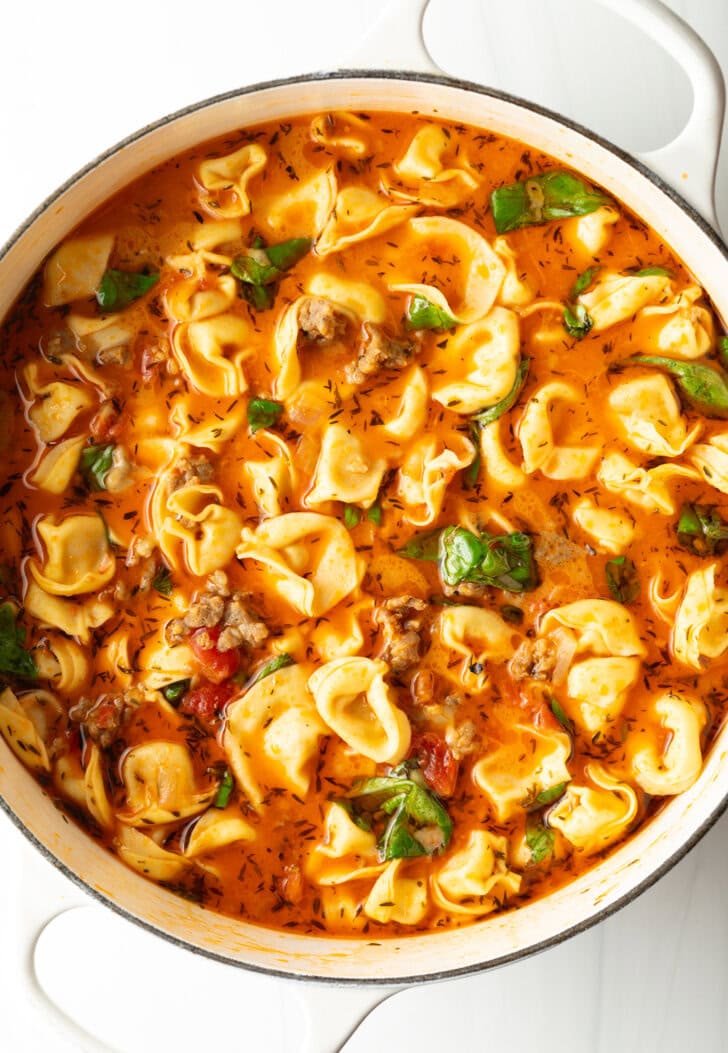 Top down view, pot of sausage soup with tortellini.