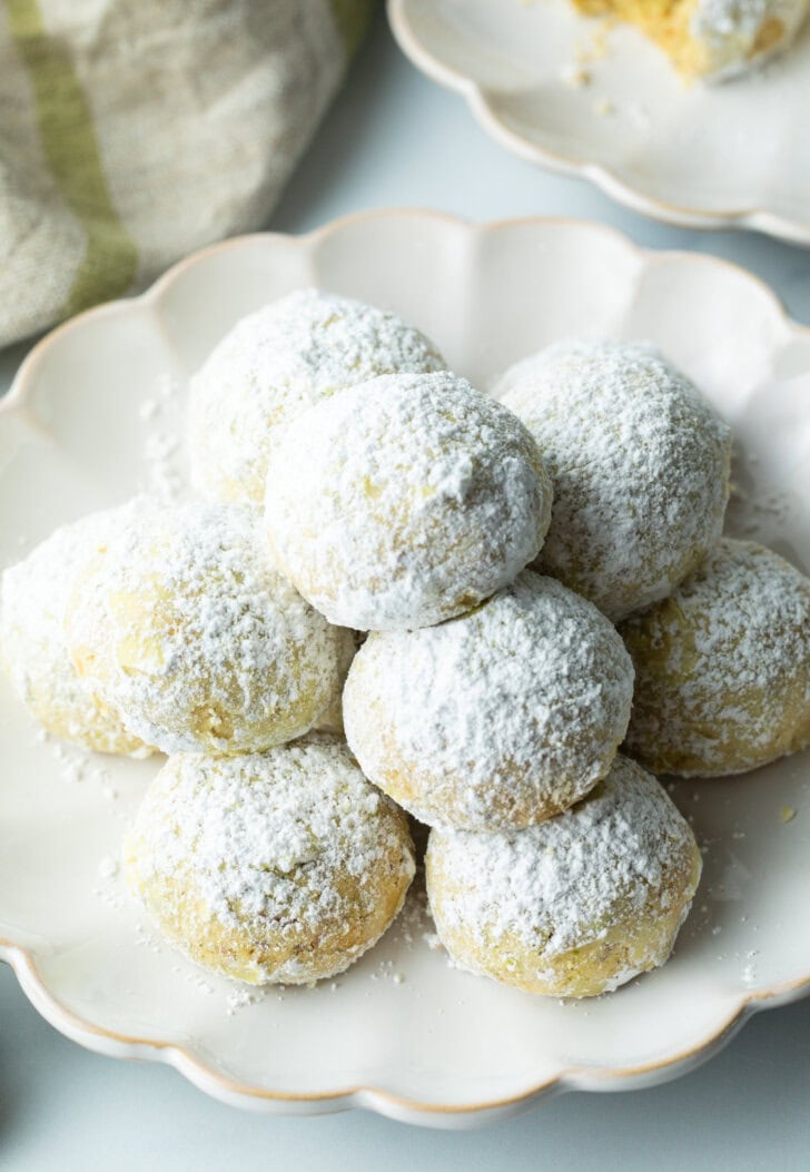 Pyramid stacks of almond and pistachio Italian wedding cookies dusted with powdered sugar.